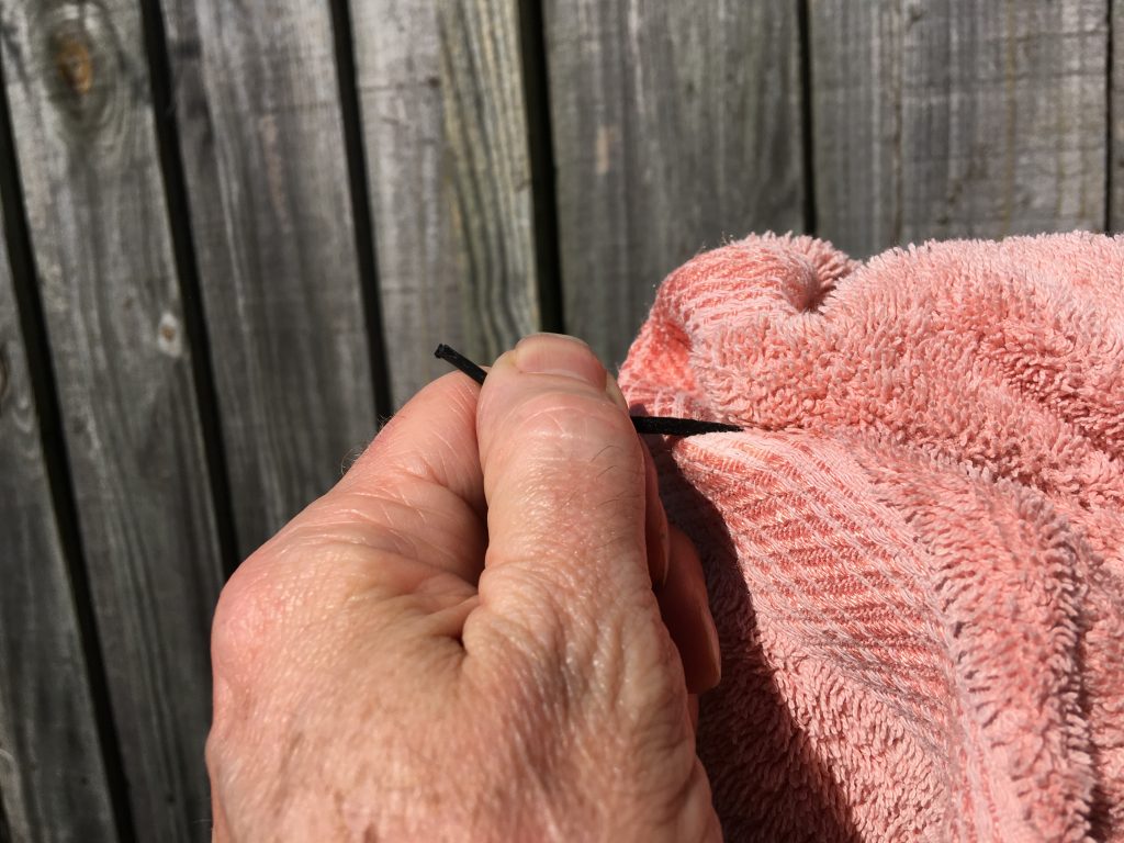 Pulling wet shoelace through towel